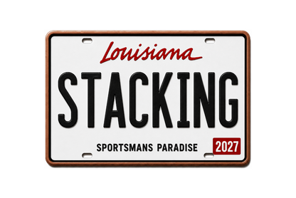 A novelty license plate sign featuring the word 'Louisiana' in red script at the top, the word 'STACKING' in large black letters across the center, 'SPORTSMANS PARADISE' in black at the bottom, and a small red box with '2027' in the lower right corner. The plate has a white face with a brown border and is shown on a plain white background.
