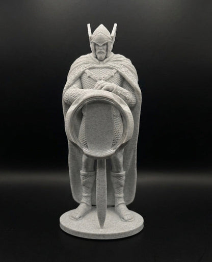 Statue of a warrior holding a sword and shield on a black background